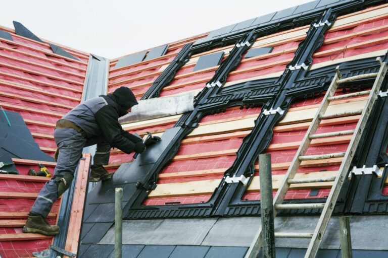 Dachdecker tauscht Ziegel auf einem Steildach aus
