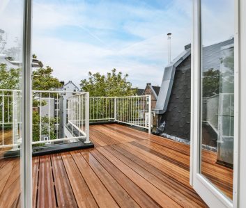 Delightful wood flooring and white railings Rooftop exterior with delightful wood flooring and white railings