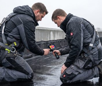 Dachdecker orten ein Leck auf dem Flachdach mit der Wärmebildkamera