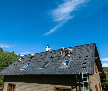 Men worker installing solar photovoltaic panels on a roof, alternative energy, saving resources and sustainable lifestyle concept.