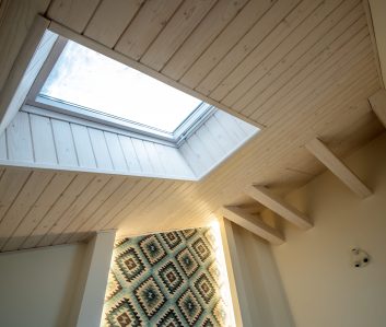Wooden ceiling in a contemporary mansard room with attic window of decorative planks surface. Wooden ceiling in a contemporary mansard room with attic window of decorative planks surface.